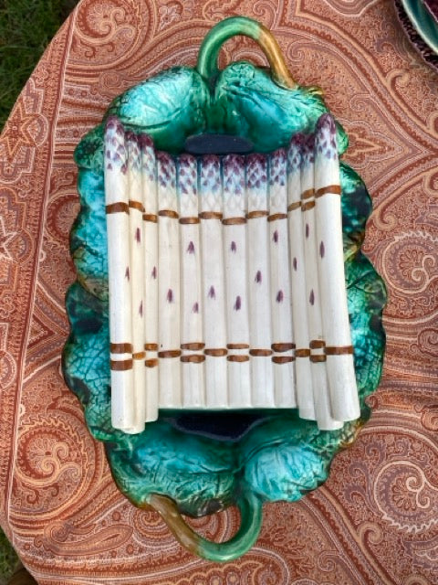 Plat à asperges ancien en barbotine sur sa feuille de chou